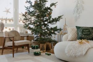 Festive living space with a decorated tree, cozy chair, and natural holiday decor. A perfect setting for holiday gatherings.