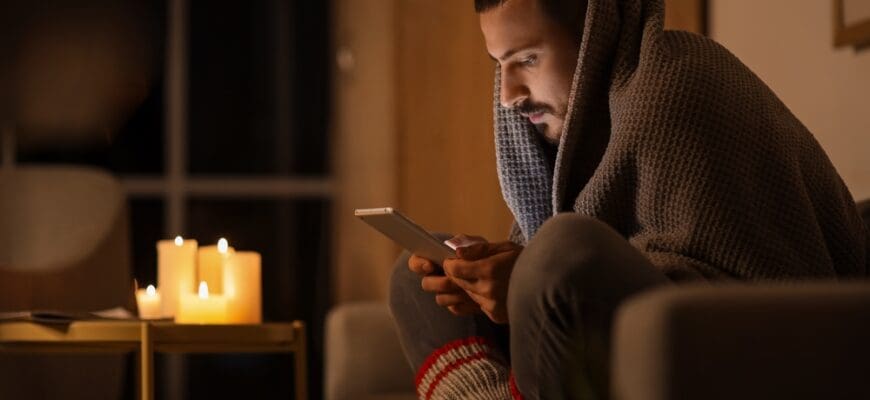 Frozen,Young,Man,Using,Tablet,Computer,On,Sofa,At,Home