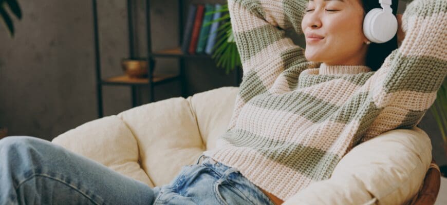 A woman lounging at home in a papasan chair