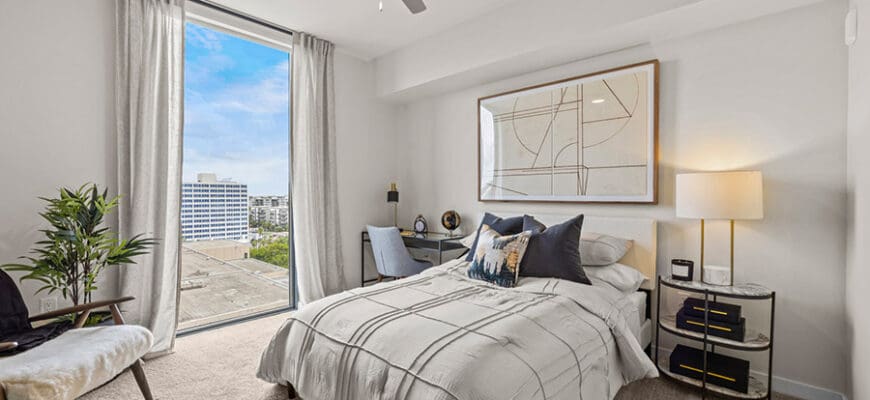 Interior bedroom at AER Tampa with a high ceiling, ceiling fan, and large window